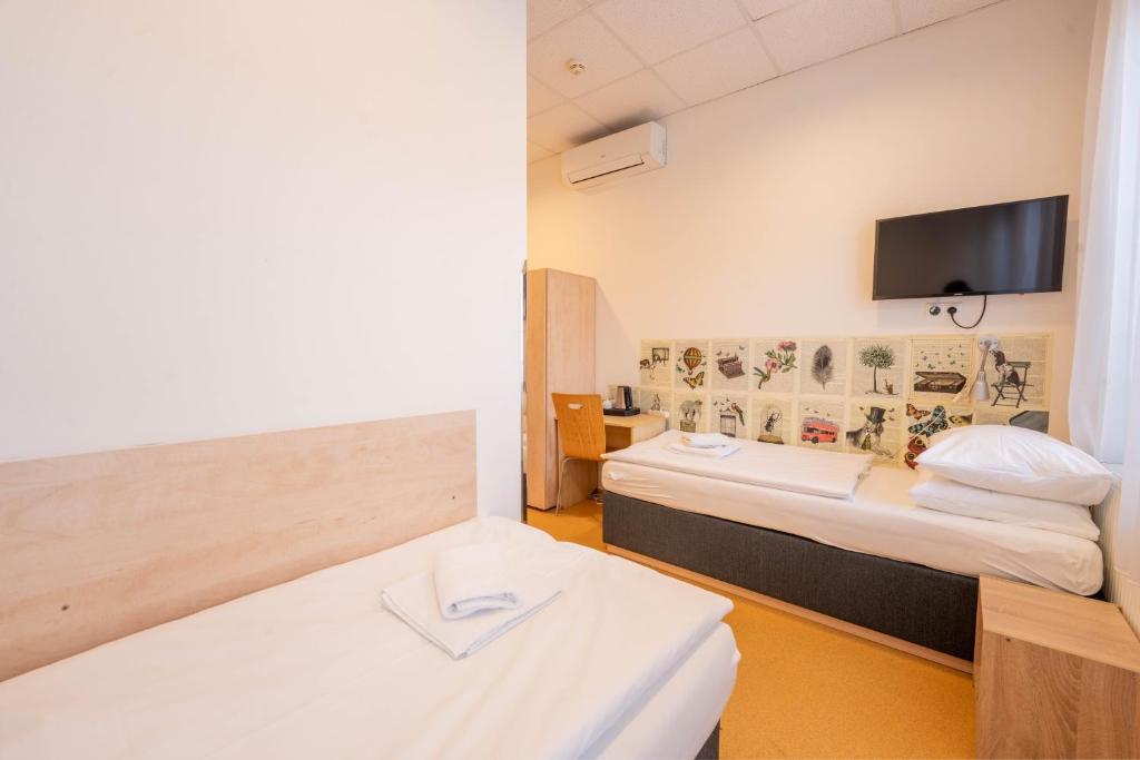 a hotel room with two beds and a flat screen tv at Drunken Monkey Hostel in Prague