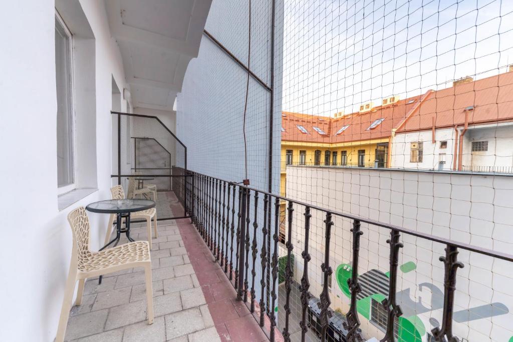 a balcony with a table and chairs on a building at Drunken Monkey Hostel in Prague