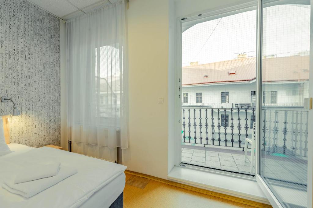 a white room with a large window and a balcony at Drunken Monkey Hostel in Prague