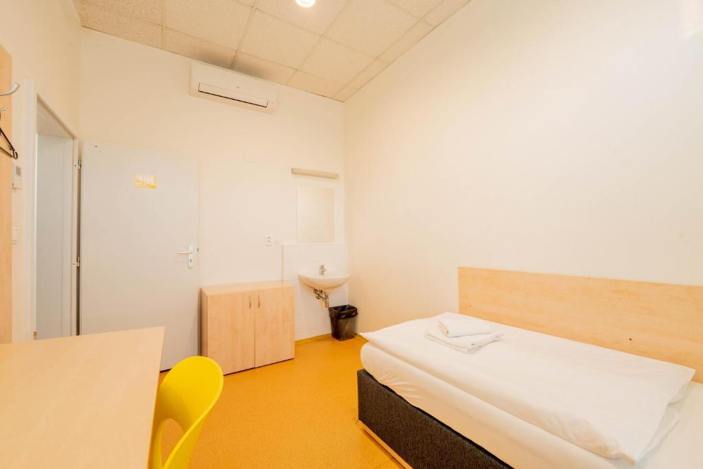 a bedroom with a bed and a desk and a table at Drunken Monkey Hostel in Prague