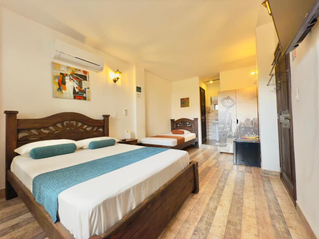 a hotel room with two beds and a bathroom at Hotel Altana in Cali