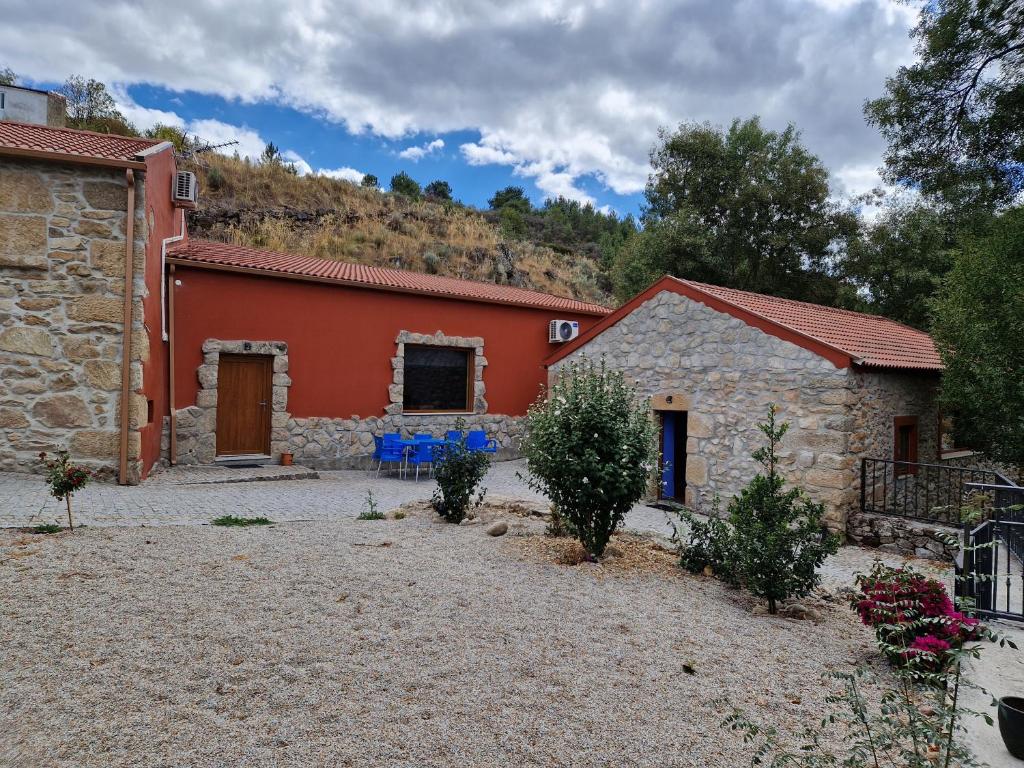 an exterior view of a house with a red building at Moinhos da Pereira - Turismo Rural in Tarouca