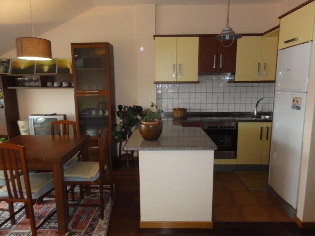 a kitchen with a table and a dining room at Apartamento Playa Langosteira in Fisterra
