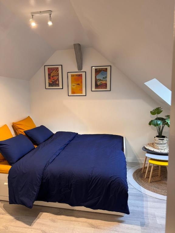 een slaapkamer met een blauw bed op een zolder bij La Planque des Halles - Hyper Centre - Bureau in Troyes