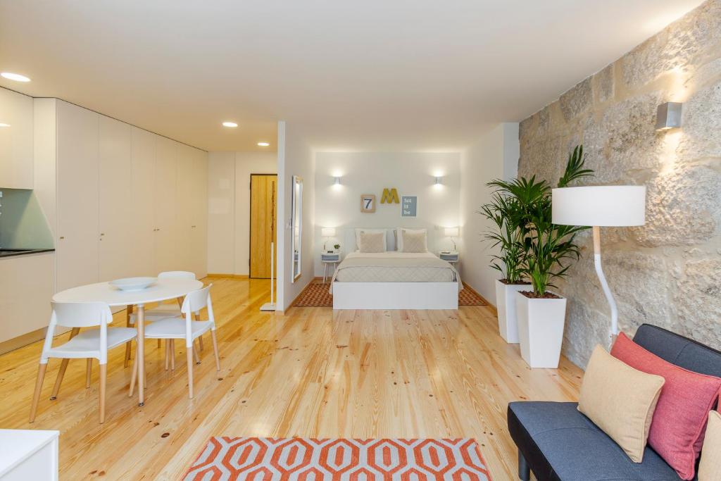 ein Wohnzimmer mit einem Tisch und einem Bett in der Unterkunft Oporto Local Studios in Porto