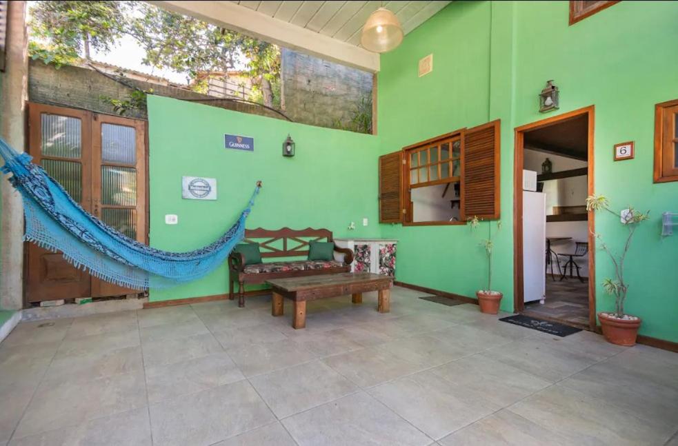 a living room with a green wall with a bench at Buzios Casa #6 in Búzios