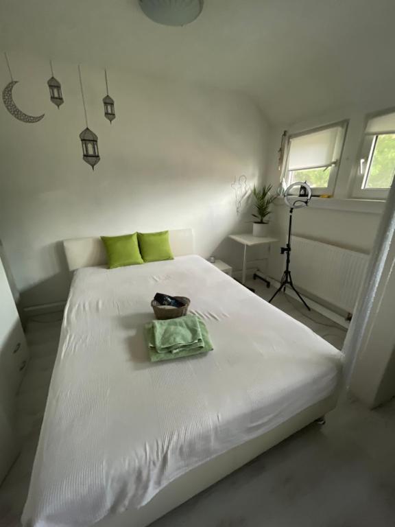 ein weißes Bett mit einer Schüssel darüber in der Unterkunft Room near fair, Zimmer neben der Messe in Frankfurt am Main