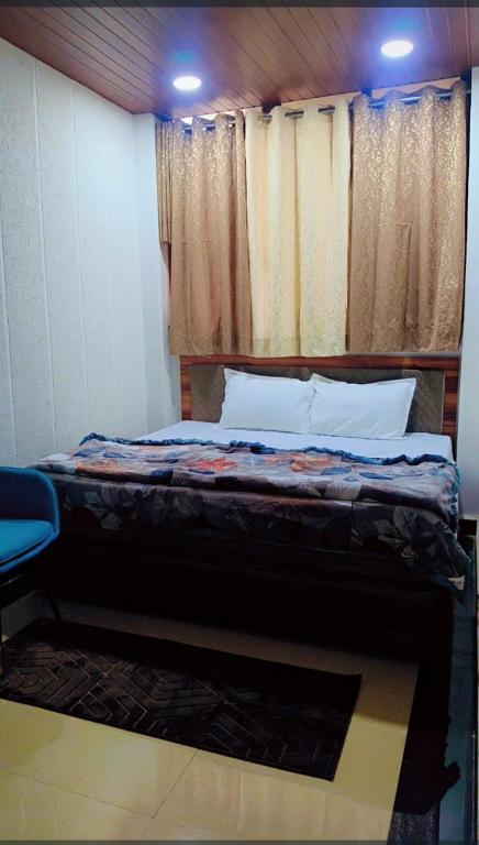 a bedroom with a bed and a window with curtains at Unnati Guest House in Vrindāvan