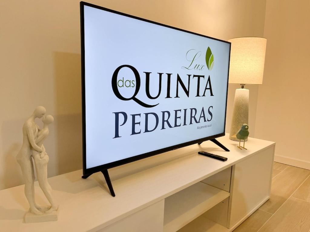 a flat screen tv sitting on top of a table at Quinta das Pedreiras Lux in Pico da Pedra