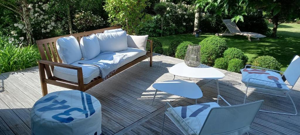 un canapé et des chaises sur une terrasse en bois dans l'établissement A Loctudy Splendide villa à 300 mètres de la plage, à Loctudy