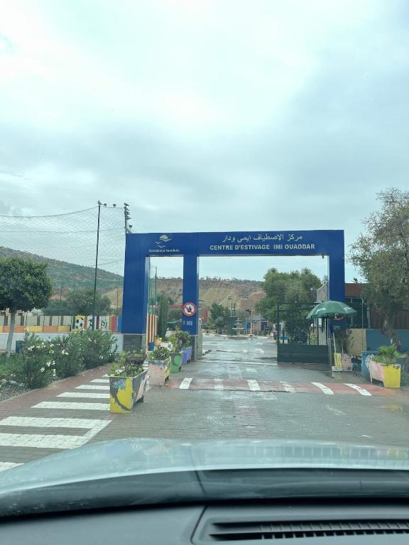 a gas station with a blue arch in the road at Centre D'estivage Imi Ouaddar in Agadir nʼ Aït Sa