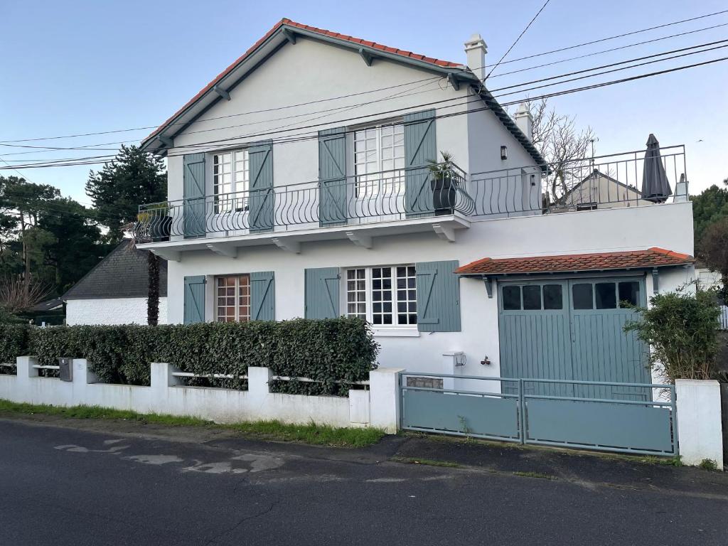 une maison blanche avec un garage vert dans l'établissement Villa Denim, à La Baule