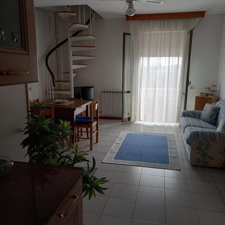 a living room with a couch and a table at Appartamento Hellas in Marotta