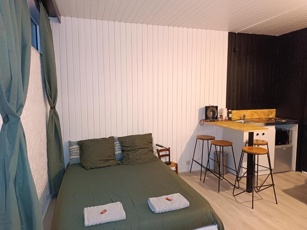 a bedroom with a bed and a table in it at LE GOOD TRIP studio à 3 min du Futuroscope in Chasseneuil-du-Poitou