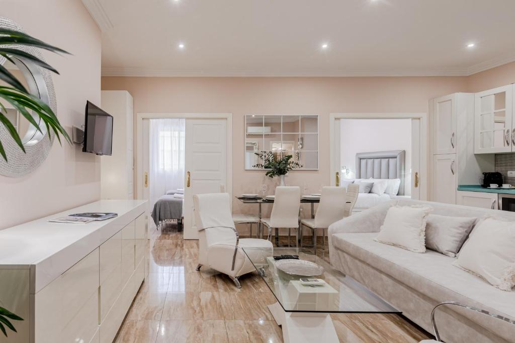 een woonkamer met een witte bank en een tafel bij ISG Apartments Jose de Velilla Centro Parking in Sevilla