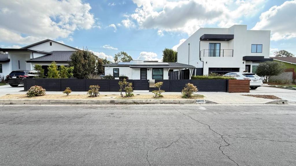 a white house with a fence and a parking lot at Modern Studio Stylish &Cozy Ieft Unit in Los Angeles