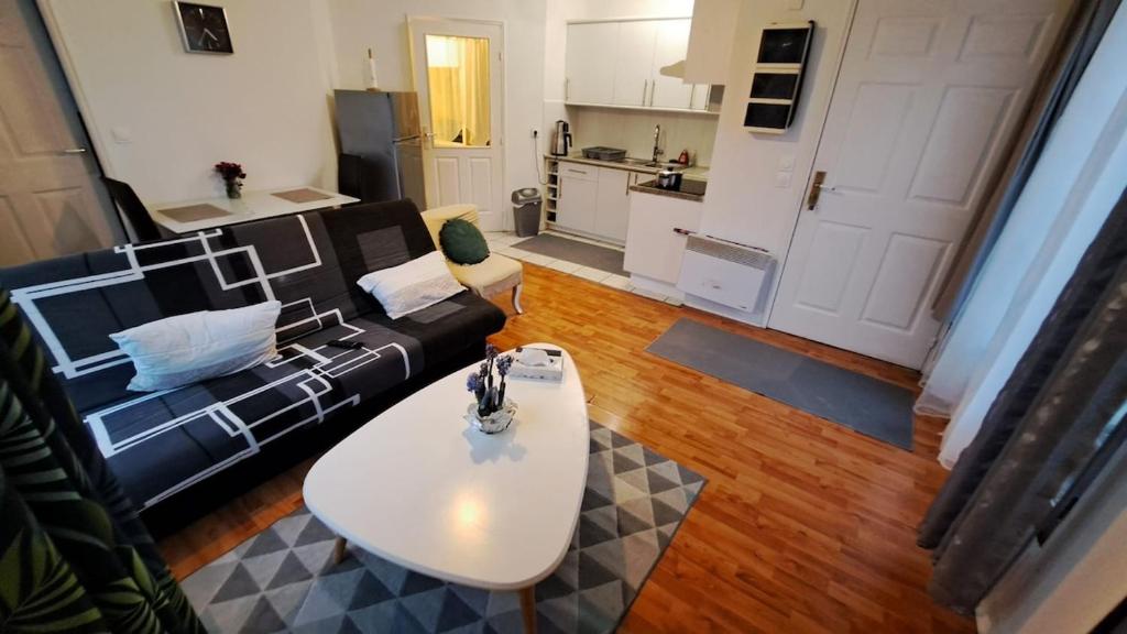 - un salon avec un canapé noir et une table blanche dans l'établissement Cozy apartment near Paris, à Domont