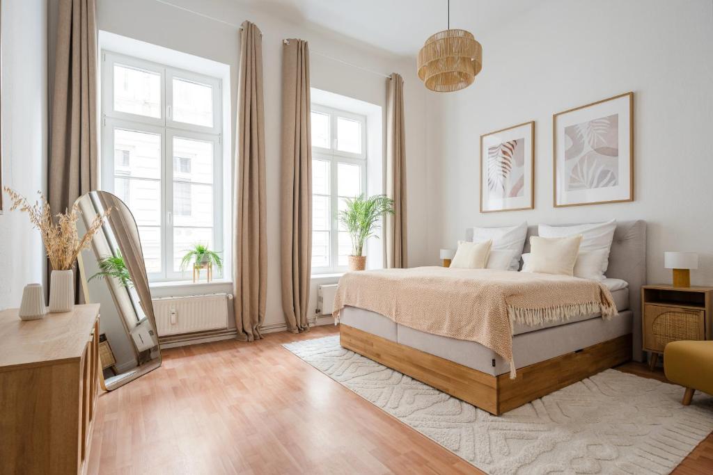 a white bedroom with a bed and two windows at Alster Boho Apartment auf 150qm für bis zu 9 Gäste in Hamburg