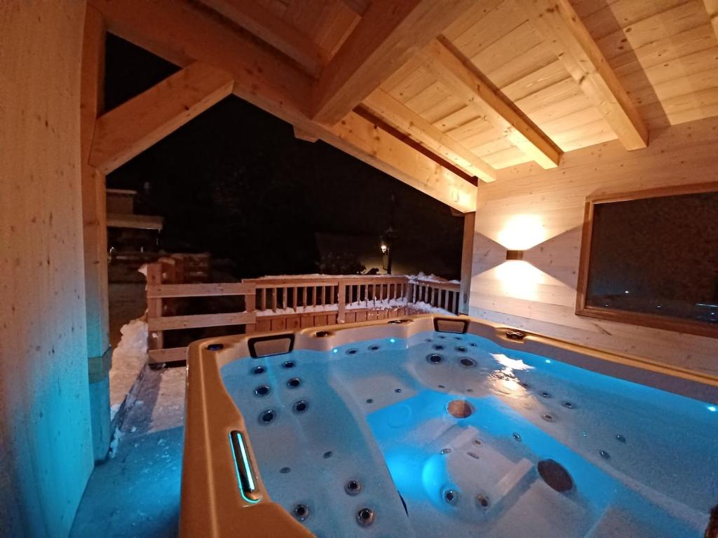 een grote hot tub in een kamer met een tv bij La grange d'Ernestia in Bourg-Saint-Maurice