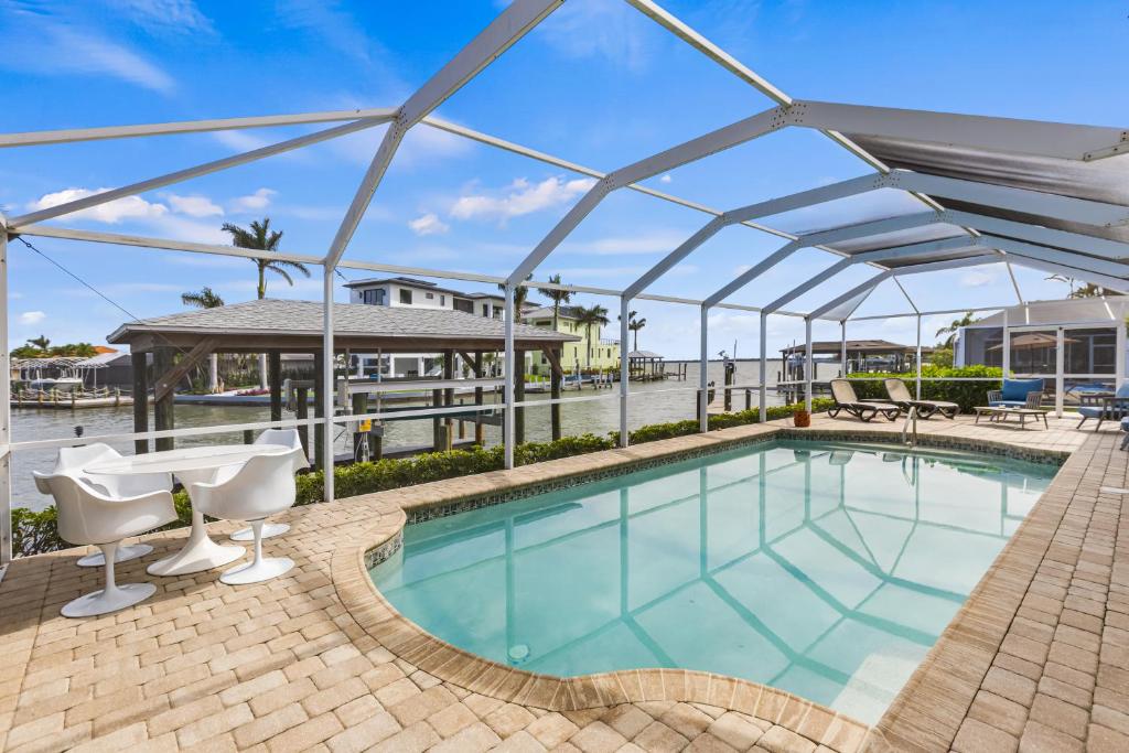 a swimming pool with a canopy over it at Waterfront! Canal View, dock Heated Pool - The Fair View of the Bay - Roelens in Fort Myers Beach