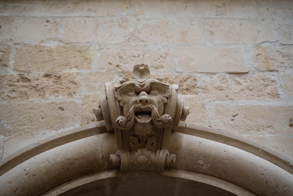 a stone lion gargoyle on a brick wall at Mary Apt - Historical Residence- Lecce in Lecce