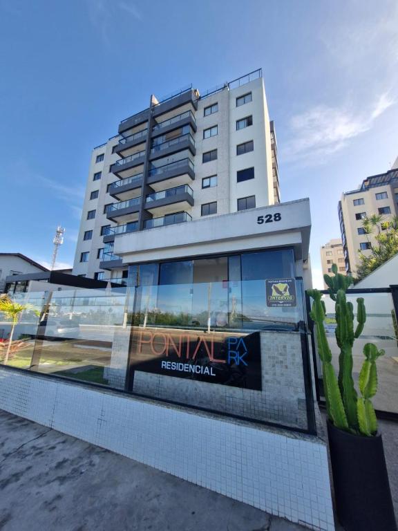 a tall building with a sign in front of it at Aconchego Baia do Pontal in Ilhéus