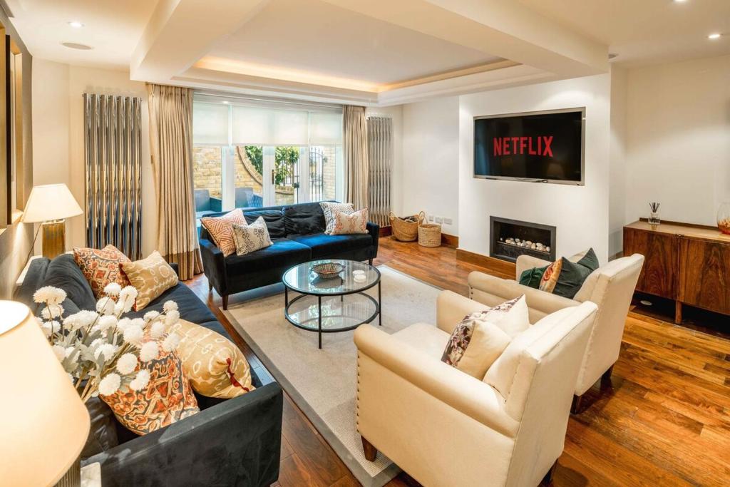 a living room with two couches and a fireplace at -Air con- Luxury Townhouse - High St Kensington! in London