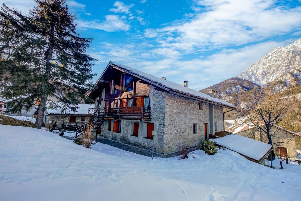 a house in the snow in the mountains at Romito Lodge Apartment Mountain Retreat - Happy Rentals in Cesana Torinese
