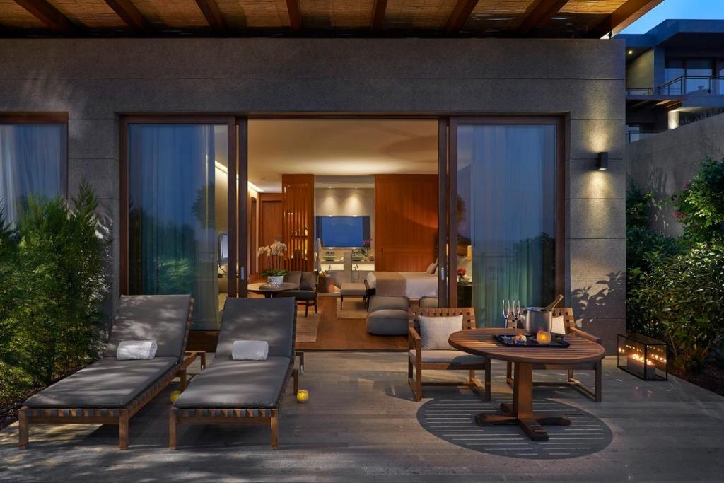 a patio with a table and chairs and a living room at Mandarin Oriental, Bodrum in Golturkbuku