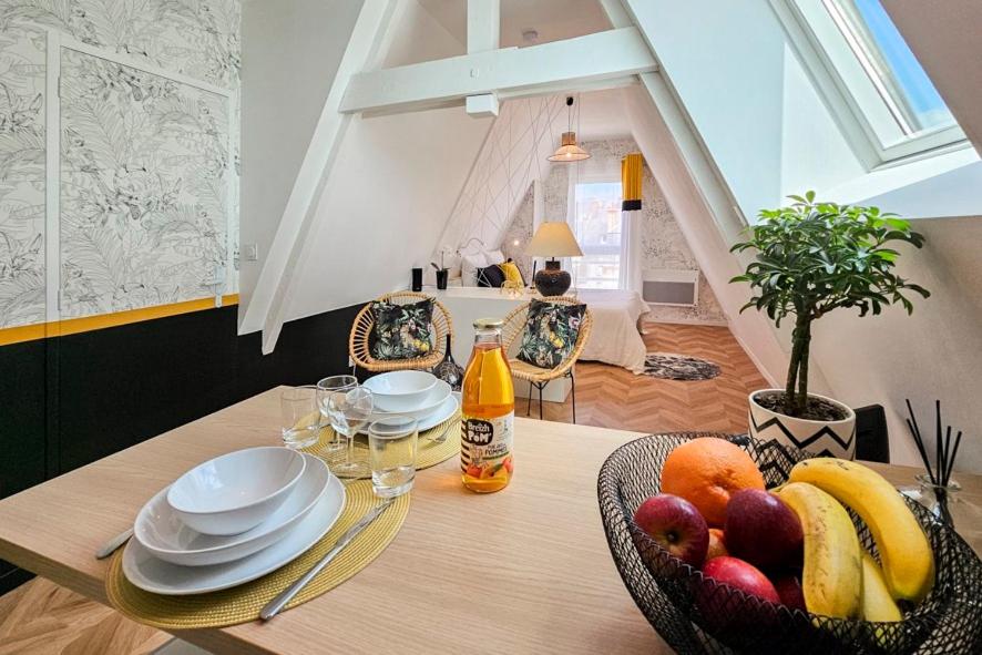 a dining room table with a bowl of fruit on it at La Canopée - calme au coeur de Fougères in Fougères