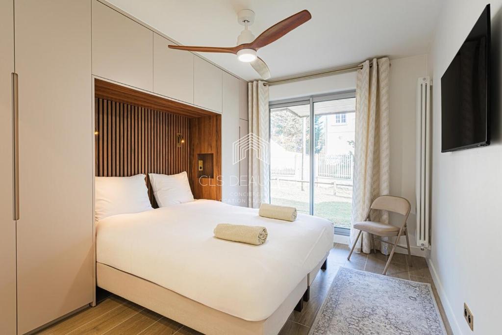 une chambre avec un grand lit blanc et une fenêtre dans l'établissement Azur & Sable Appart de Standing à 100m Mer CLS Deauville, à Benerville-sur-Mer