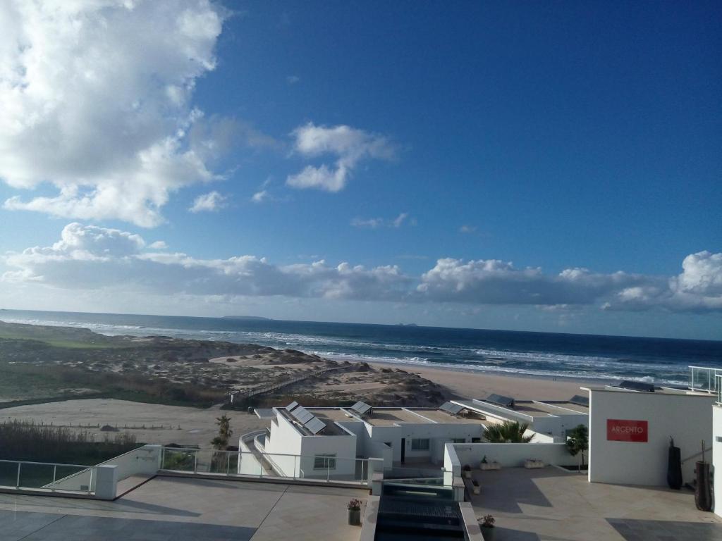 uma vista para a praia e para o oceano a partir de um edifício em Praia Del Rey SeaView Dupplex em Casal da Lagoa Seca