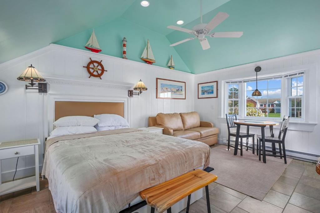 a bedroom with a large bed and a dining room at Seaside Cottages - Cottage 16 - Beach Cottage in South Yarmouth