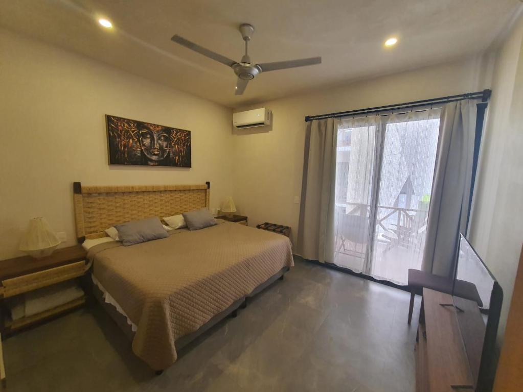 Un dormitorio con una cama y una ventana grande. en Smart Depas Elegante apartamento estudio totalmente equipado, en Tulum