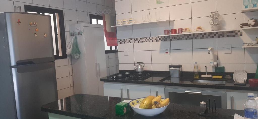 a kitchen with a bowl of bananas on a counter at Apartamento Relax Enseada Bertioga SP in Bertioga