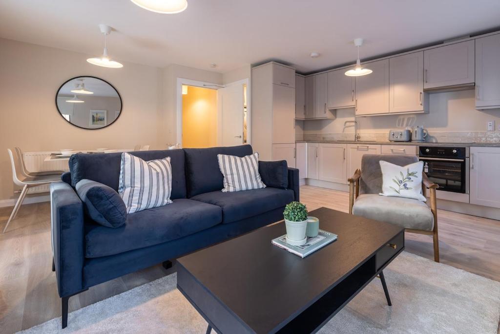 a living room with a blue couch and a table at 2nd Floor Stylish 2-Bed Apartment in Drogheda