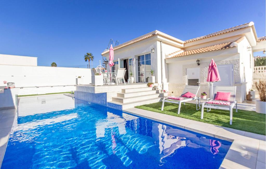 eine Villa mit einem Swimmingpool vor einem Haus in der Unterkunft 3 Bedroom Cozy Home In Rojales in Rojales