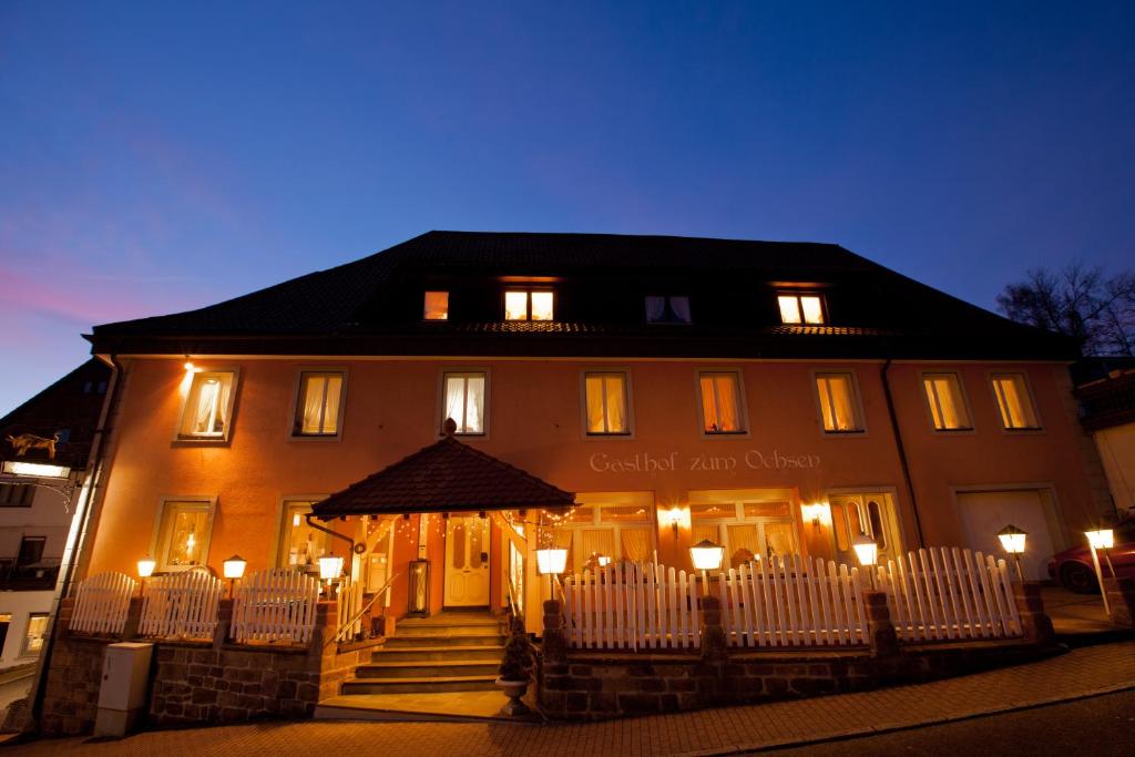 un edificio con una valla blanca delante de él en Gasthof zum Ochsen, en Vöhrenbach