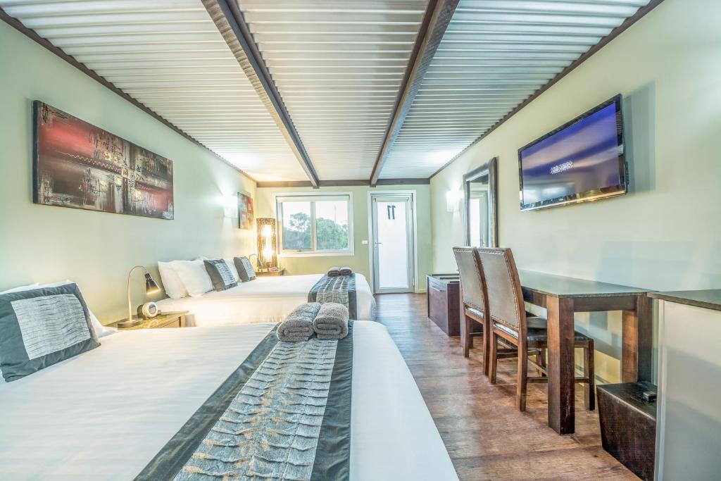Zimmer mit einem Bett, einem Tisch und einem TV in der Unterkunft Orbost Motel in Orbost