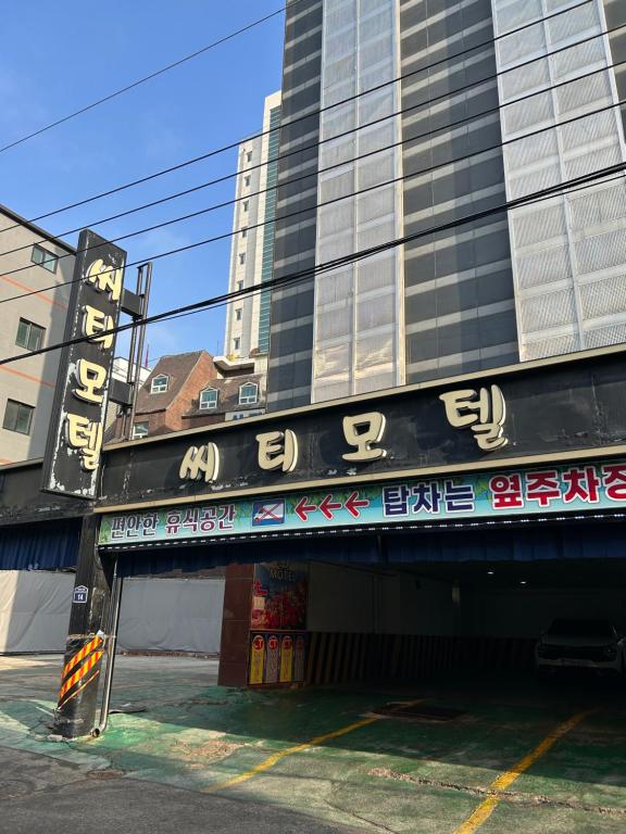 Un edificio con un cartel al costado. en City Motel, en Hanam