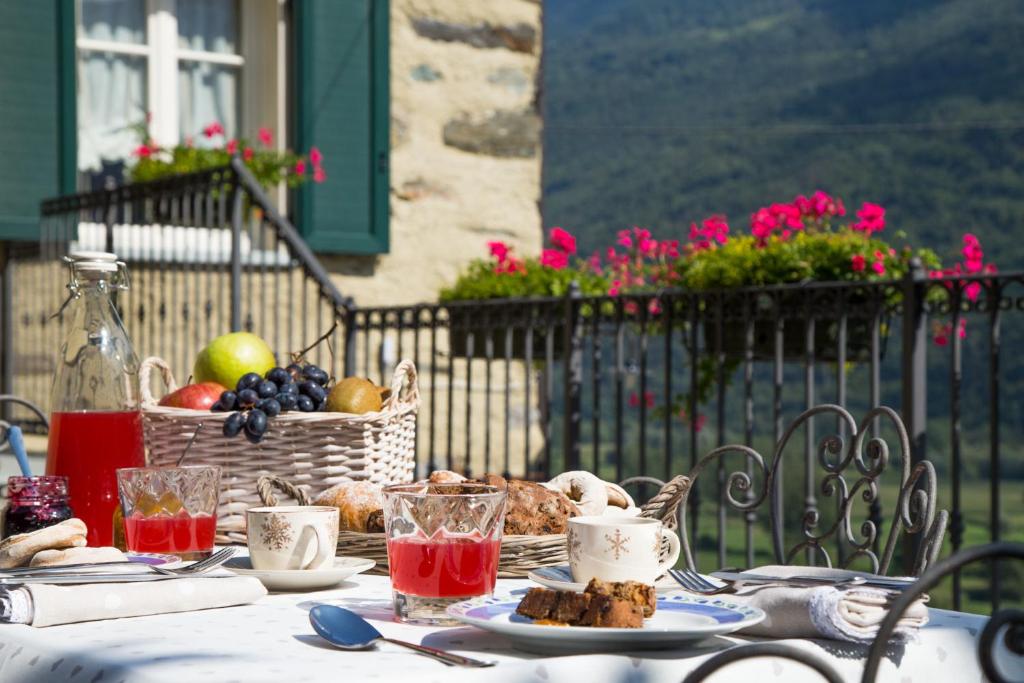 a table with food and a basket of fruit at B&B Ca' La Vedescia in Teglio