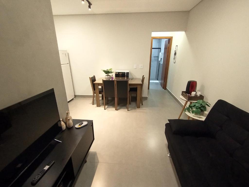 uma sala de estar com uma mesa e uma sala de jantar em Residencial Verônica 06 - Apartamento de 1 quarto próximo ao centro em Marília