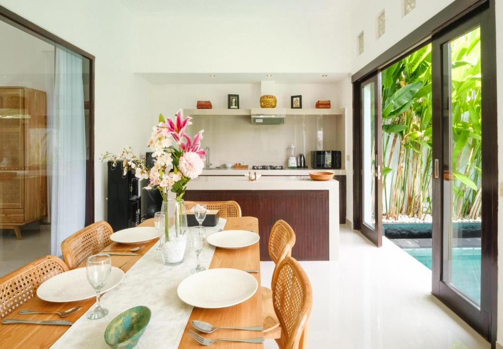 une cuisine et une salle à manger avec une table et des chaises en bois dans l'établissement Gemstones Villa, à Seminyak