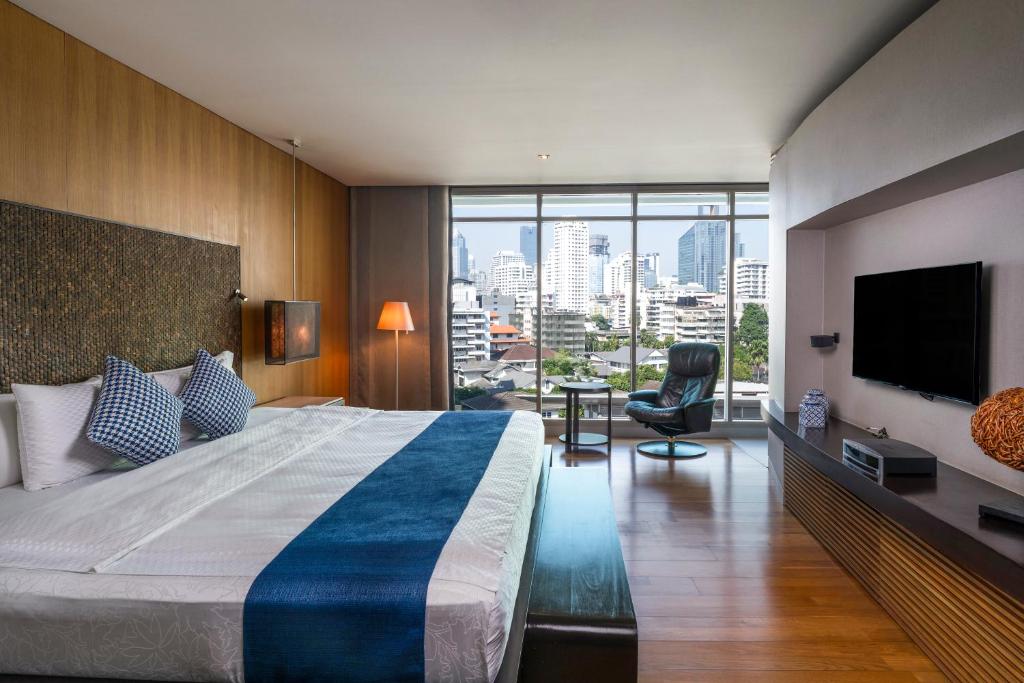 a hotel room with a large bed and a large window at TUI BLUE Maduzi Hotel Bangkok in Bangkok