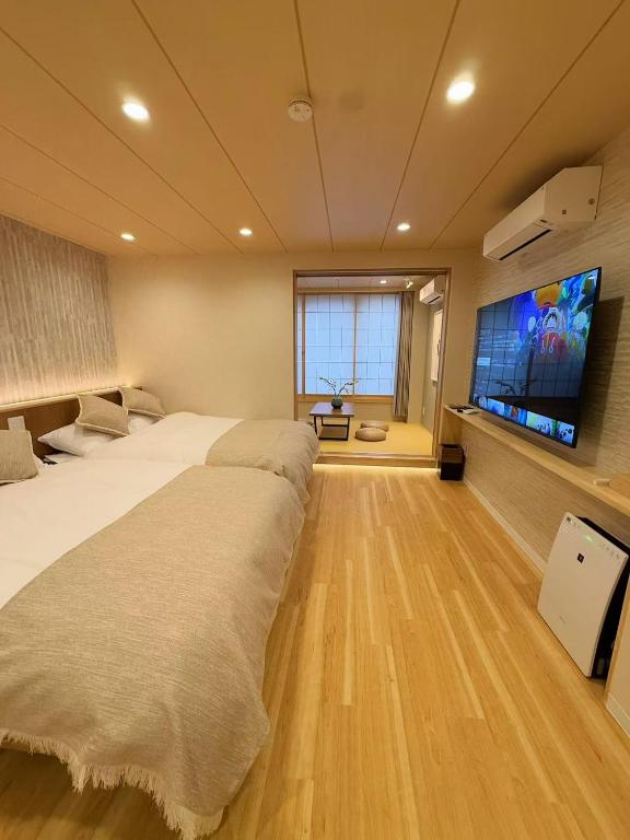 a bedroom with two beds and a flat screen tv at M house asakusa kaminarimon tokyo in Tokyo