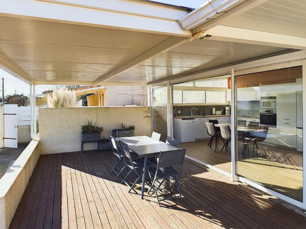 un patio extérieur avec une table et une cuisine dans l'établissement Villa 3 chambres climatisée près de la plage avec parking privé à Marseillan-Plage - FR-1-326-845, à Marseillan