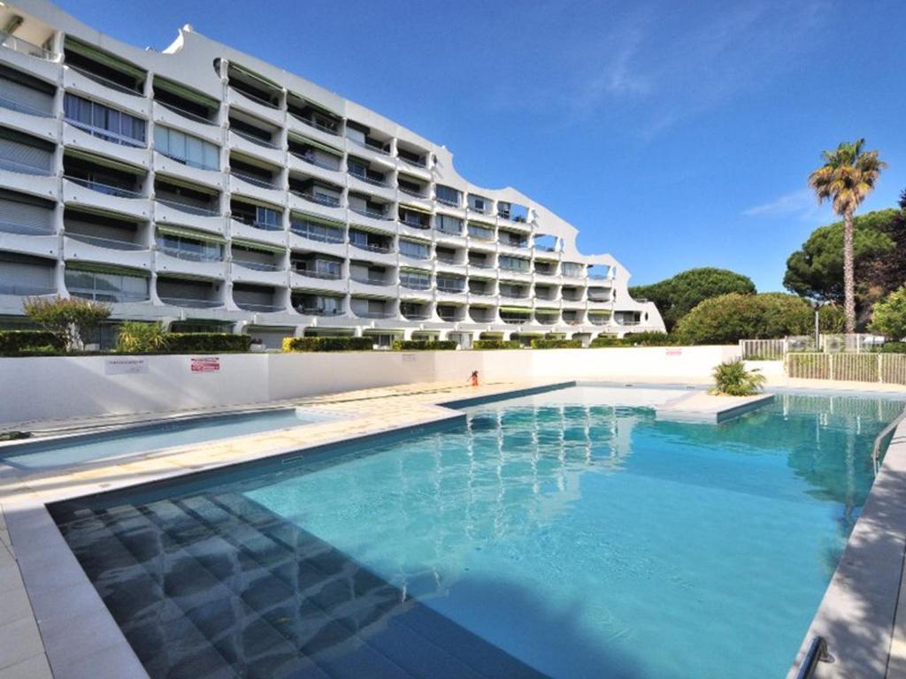 une piscine en face d'un grand bâtiment dans l'établissement Studio Cabine avec Vue Piscine, Parking Privé - FR-1-328-274, à La Grande Motte