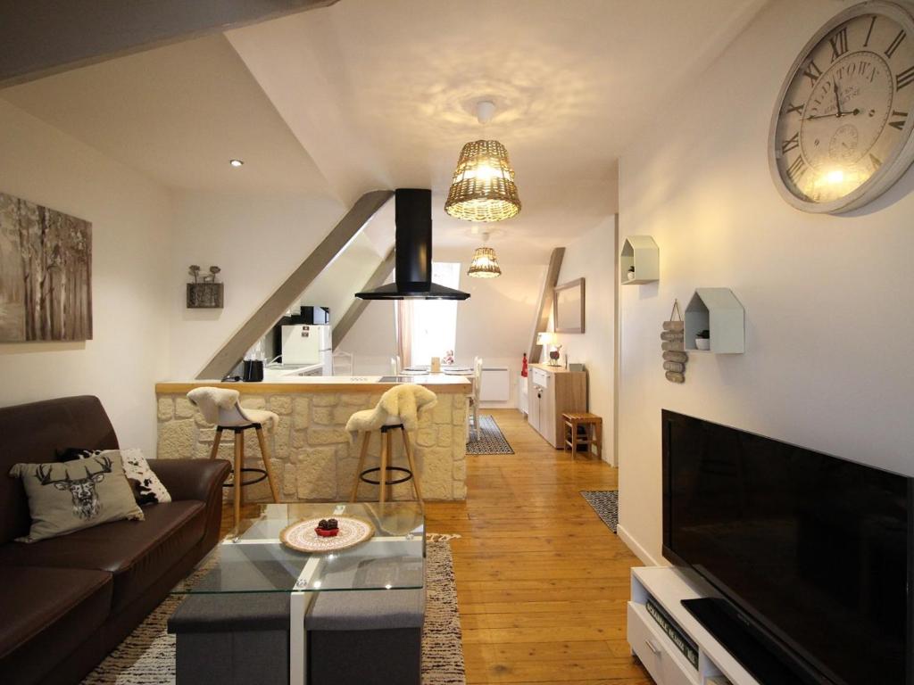 un salon avec un canapé et une horloge au mur dans l'établissement Spacieux T3 La Bourboule, 2 chambres, proche thermes - FR-1-608-284, à La Bourboule