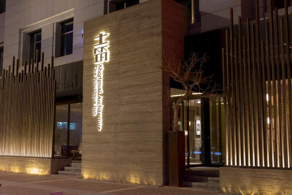 a building with a sign on the side of it at Jiayuguan Tuzhu Hotel in Jiayuguan