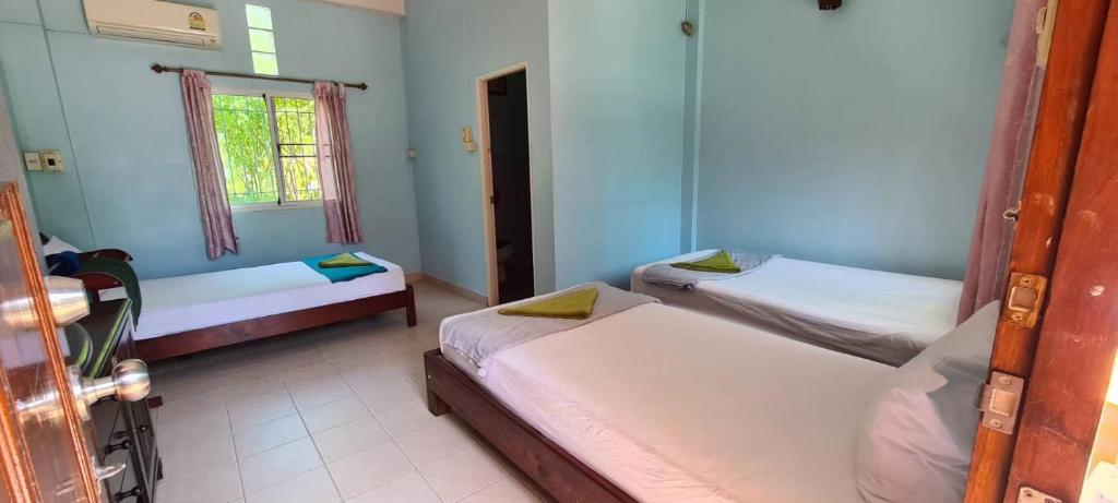 Postel nebo postele na pokoji v ubytování Sarin Guesthouse สาริน